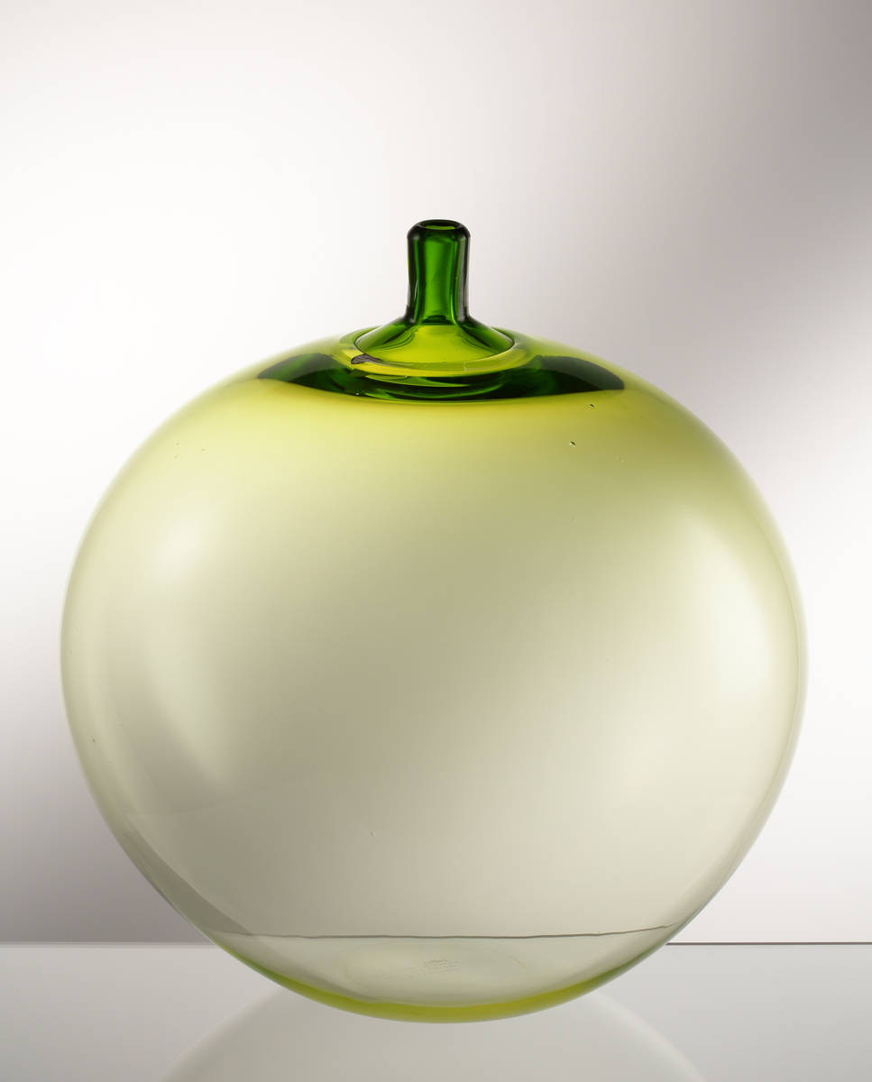 Vas "Äpplet".
Art.nr. 32-57.
Konstnär: Ingeborg Lundin.
Runt äpple med hals. Gulgröntonad.
Friblåst, driven hals.
Märkt med sköldformad, vinröd etikett med vit orre och text. 

Inskrivet i huvudkatalogen tidigast 1998.