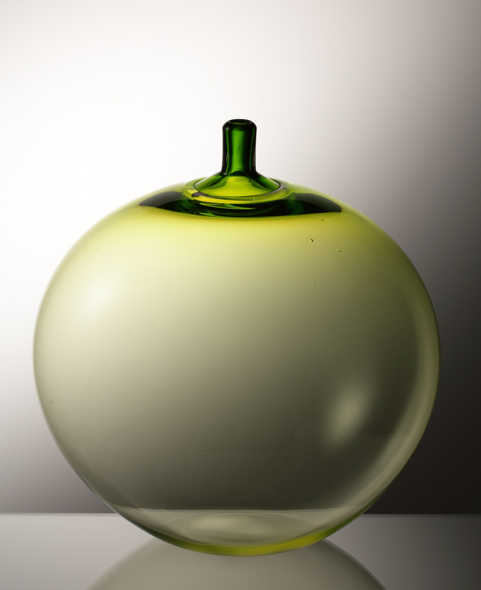 Vas "Äpplet".
Art.nr. 32-57.
Konstnär: Ingeborg Lundin.
Runt äpple med hals. Gulgröntonad.
Friblåst, driven hals.
Märkt med sköldformad, vinröd etikett med vit orre och text. 

Inskrivet i huvudkatalogen tidigast 1998.