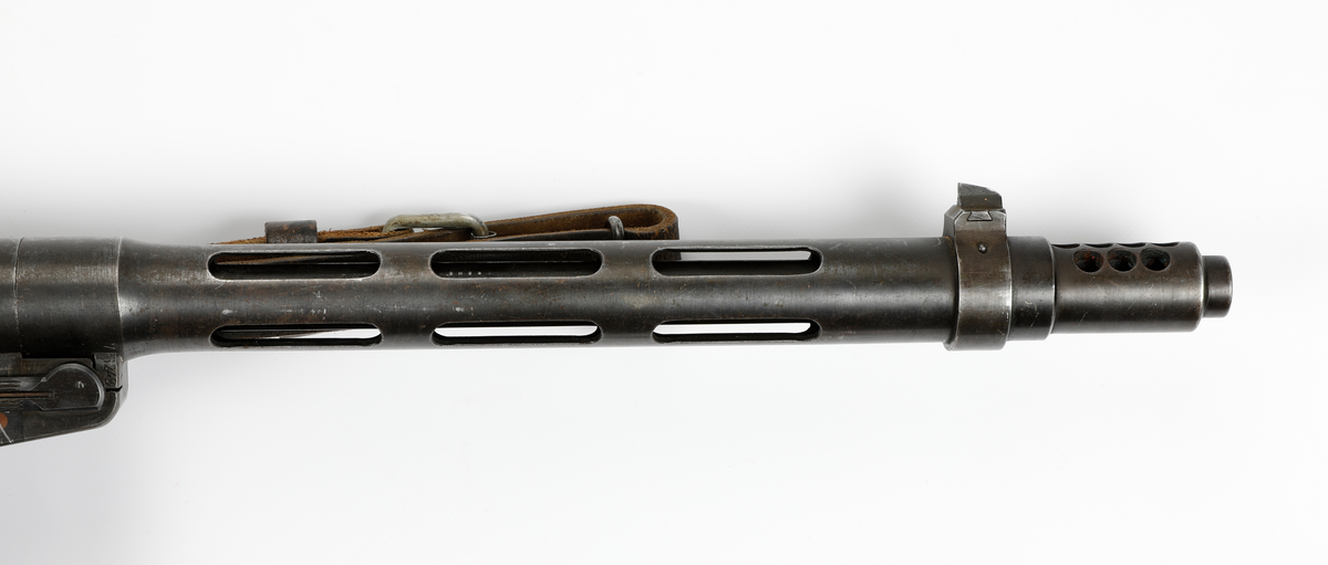 Våpenet er en finsk maskinpistol med betegnelsen Suomi MG-31 og ble produsert av det finske selskapet «Tikkakoski Oy»,
Kalibret er 9x19 mm Parabellum med 20 skudds stavmagasin, men kunne også ha et 70 skudds trommelmagasin.
Våpennummer 76243.
Våpenet ble utlevert til Jens Bekkemoen fra Elverum under sitt opphold i Sverige under andre verdenskrig hvor han fikk opplæring sammen med øvrige norske styrker som var der. Han var der fra 20/11-1943 til 30/7-1944.
Bekkemoen deltok under kampene i 1940 på vestsiden av Mjøsa og ble til slutt tatt som fange av tyskerne på Lillehammer.

Etter oppholdet i Sverige var han med i milorgdistrikt D-24 og deres aktivitet ved «Gjestegiveriet» på Hestberget i Våler under ledesle av Lingemannen Oddvar Dobloug. Etter at hytta ble tatt av tyskerne ble han med i motstandshytta «Røysa» under ledelse av distriktssjef Leif Nordberg.
Han tjenset besto i mottagelse av og lagring av våpen – transport av materiell, samt instruksjon i Mil-org. Deltok også i jernbanesabotasje i januar 1945.