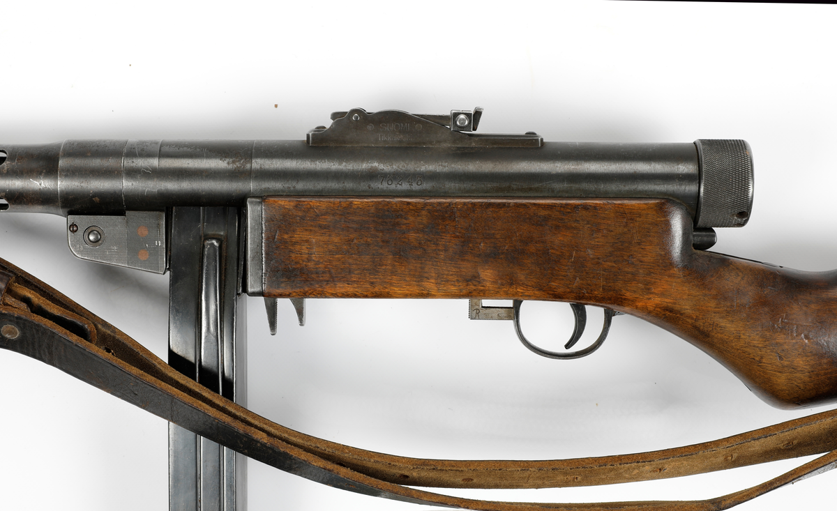 Våpenet er en finsk maskinpistol med betegnelsen Suomi MG-31 og ble produsert av det finske selskapet «Tikkakoski Oy»,
Kalibret er 9x19 mm Parabellum med 20 skudds stavmagasin, men kunne også ha et 70 skudds trommelmagasin.
Våpennummer 76243.
Våpenet ble utlevert til Jens Bekkemoen fra Elverum under sitt opphold i Sverige under andre verdenskrig hvor han fikk opplæring sammen med øvrige norske styrker som var der. Han var der fra 20/11-1943 til 30/7-1944.
Bekkemoen deltok under kampene i 1940 på vestsiden av Mjøsa og ble til slutt tatt som fange av tyskerne på Lillehammer.

Etter oppholdet i Sverige var han med i milorgdistrikt D-24 og deres aktivitet ved «Gjestegiveriet» på Hestberget i Våler under ledesle av Lingemannen Oddvar Dobloug. Etter at hytta ble tatt av tyskerne ble han med i motstandshytta «Røysa» under ledelse av distriktssjef Leif Nordberg.
Han tjenset besto i mottagelse av og lagring av våpen – transport av materiell, samt instruksjon i Mil-org. Deltok også i jernbanesabotasje i januar 1945.