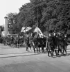 Nykterhetsfolkets dag. Scoutmarsch (flickscouter i täten) med fanor, genom entrén till jubileumsutställningen.