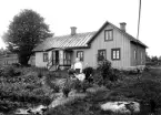 Familj framför okänd stuga, 1905