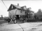 Handelsbod, okänd plats i Kronobergs län, ca 1900. En familj står framför det stora huset.