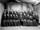 Konfirmander med präst fotograferade i ateljé. Ca. 1900. Fotograferat i makarna Forthmeiiers ateljé.