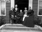Familj på trappa vid bostadshus. Ca. 1900.