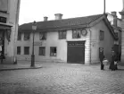 Bekanta råkas i ett hörn av Stora torget i Linköping. Vad som dryftades kan vi naturligtvis inte veta, och var ju heller inte för våra öron, men mötets tycks hjärtligt. Tiden anges varit 1913, vilket mycket väl kan stämma enligt bildens stämmning och markörer. I bakgrunden Hantverkaregatan 1 där urmakare Otto Theodor Cederqvist drev sin verksamhet.