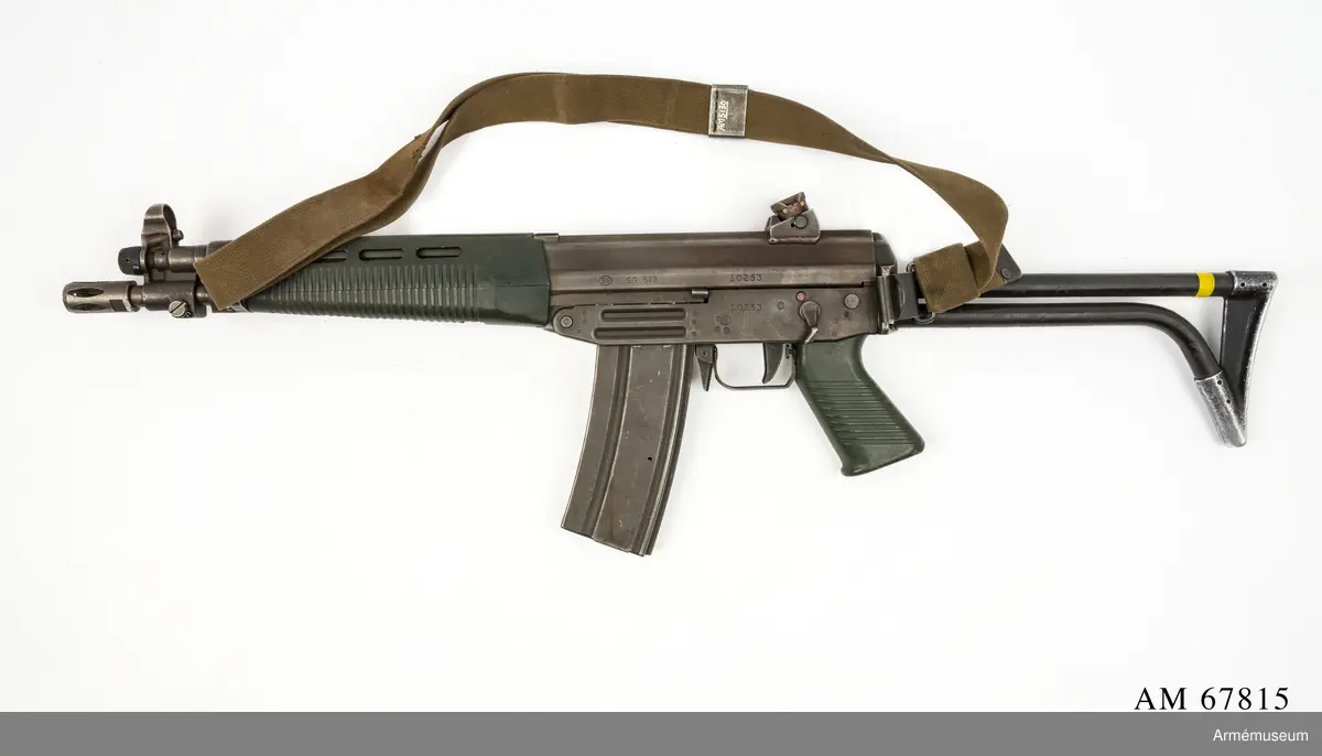 Tillverkningsnummer 10253.  Längd axelstödet i infällt läge 580 mm. Pipans längd med mynningsbroms 328 mm.
Vapnet märkt med (SIG) SG 543. Bestående av: 1 st automatkarbin, 1 st gevärsrem av väv.
