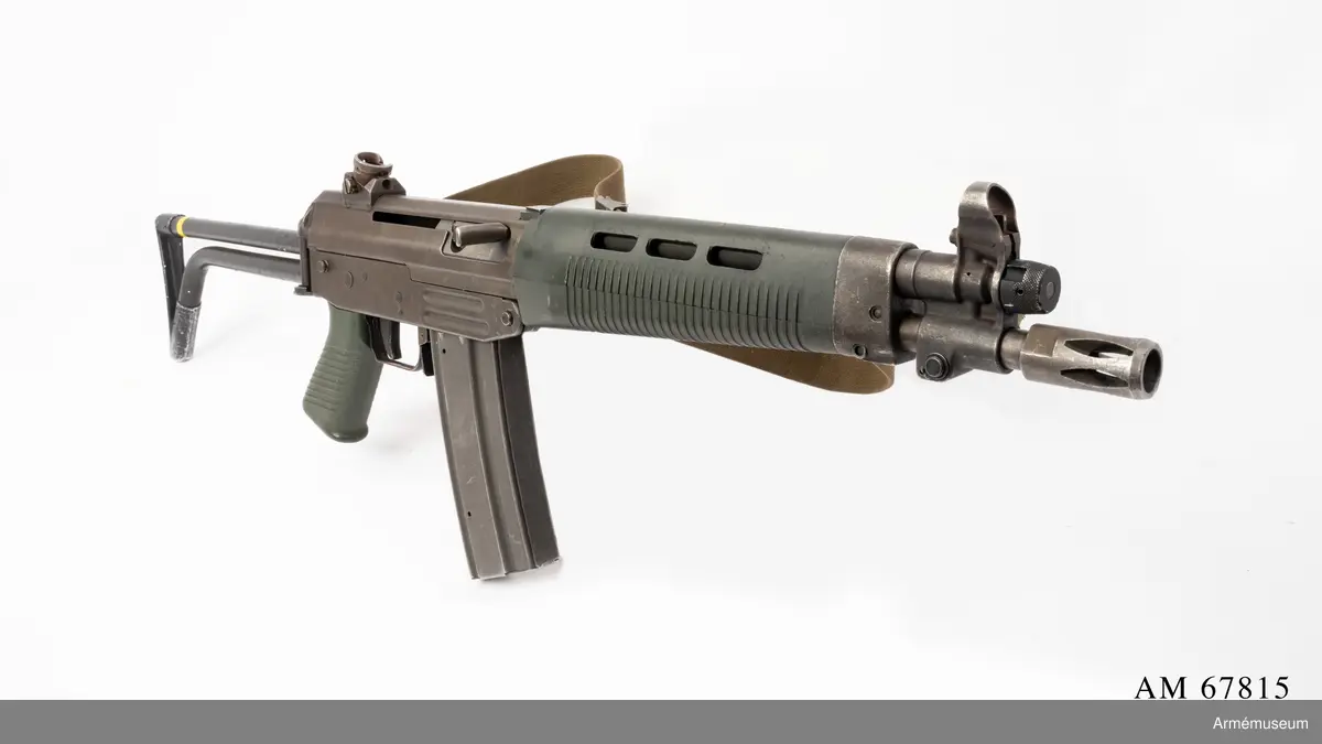 Tillverkningsnummer 10253.  Längd axelstödet i infällt läge 580 mm. Pipans längd med mynningsbroms 328 mm.
Vapnet märkt med (SIG) SG 543. Bestående av: 1 st automatkarbin, 1 st gevärsrem av väv.