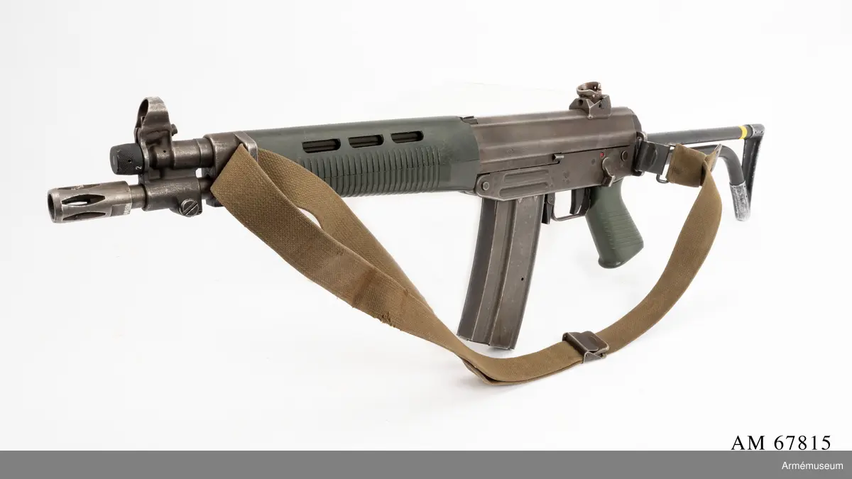 Tillverkningsnummer 10253.  Längd axelstödet i infällt läge 580 mm. Pipans längd med mynningsbroms 328 mm.
Vapnet märkt med (SIG) SG 543. Bestående av: 1 st automatkarbin, 1 st gevärsrem av väv.