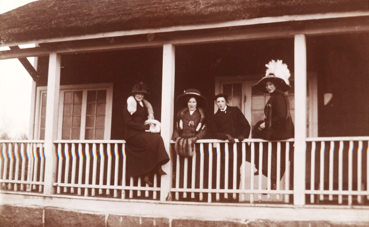 Fyra syskon Hermanson år 1912 vid verandaräcket på Tivedstugan i Påskbergsskogen. Från vänster: Ethel, Elsie, Irving och Linda. Systrarna bär stora hattar, pälsboa och -muffar. Ethel blev läroverksadjunkt; Elsie gifte sig Svanberg och blev hemmafru; Irving stred i den amerikanska armén och stupade på Västfronten; Linda övertog Linda Hansons bosättningsmagasin (senare DUKA Linda Hansons AB).

(Bilden tillhör samlingen från firma Linda Hanson.)