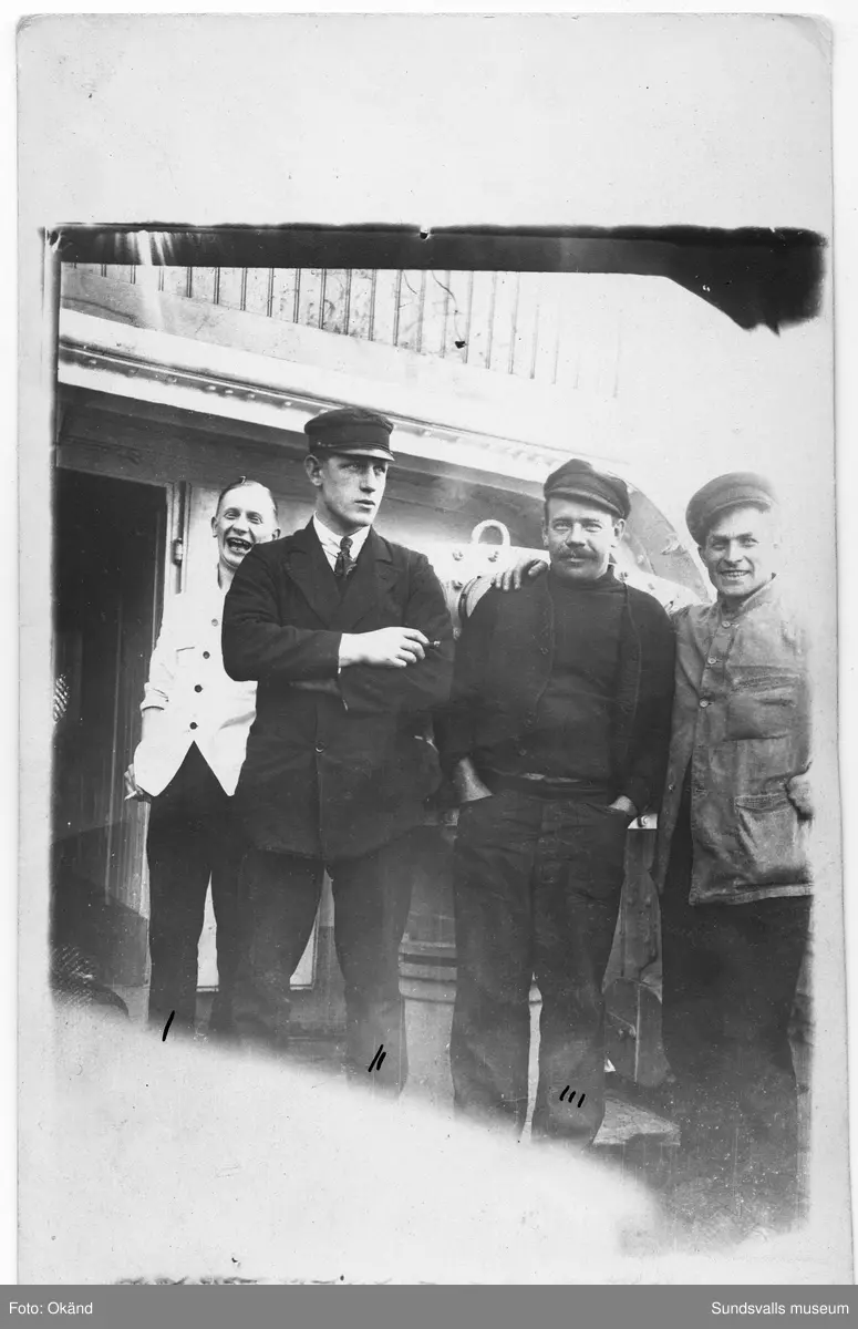 Vykort med fyra män på ett båtdäck, längst till höger Edvin Lundgren. På baksidan står: "Ombord på Belos i Kiel den 12.1.1921, den som är märkt med I det är kocken, II det är 2dra styrman, III det är Dykar Johansson å så komer jag ...". Ur en samling som tillhört Frida Viklander i Backås, Hässjö.