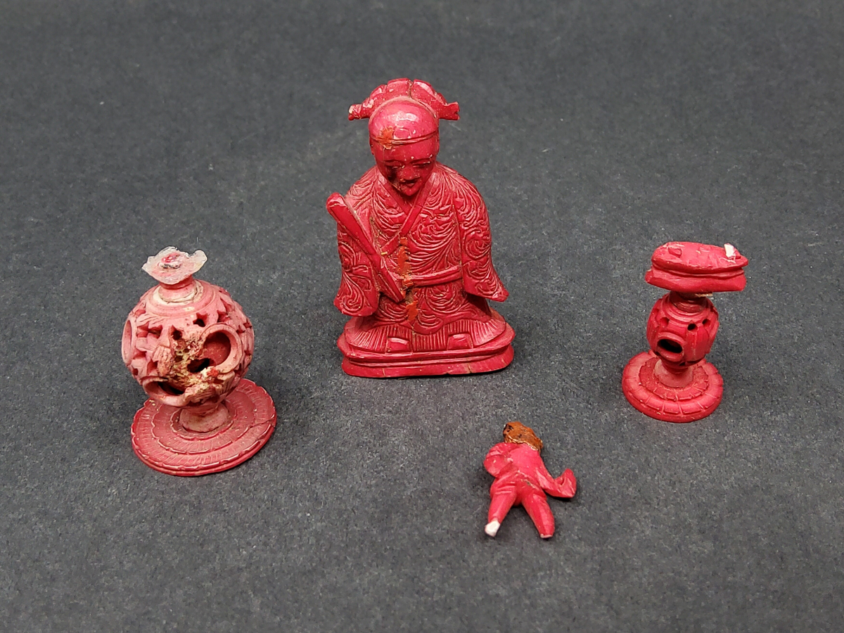 Röda och vita shackpjäser. Totalt 32 figurer. Figurerna i form av människor och elefanter. Minsta figuren 6cm. Största figuren 13 cm.