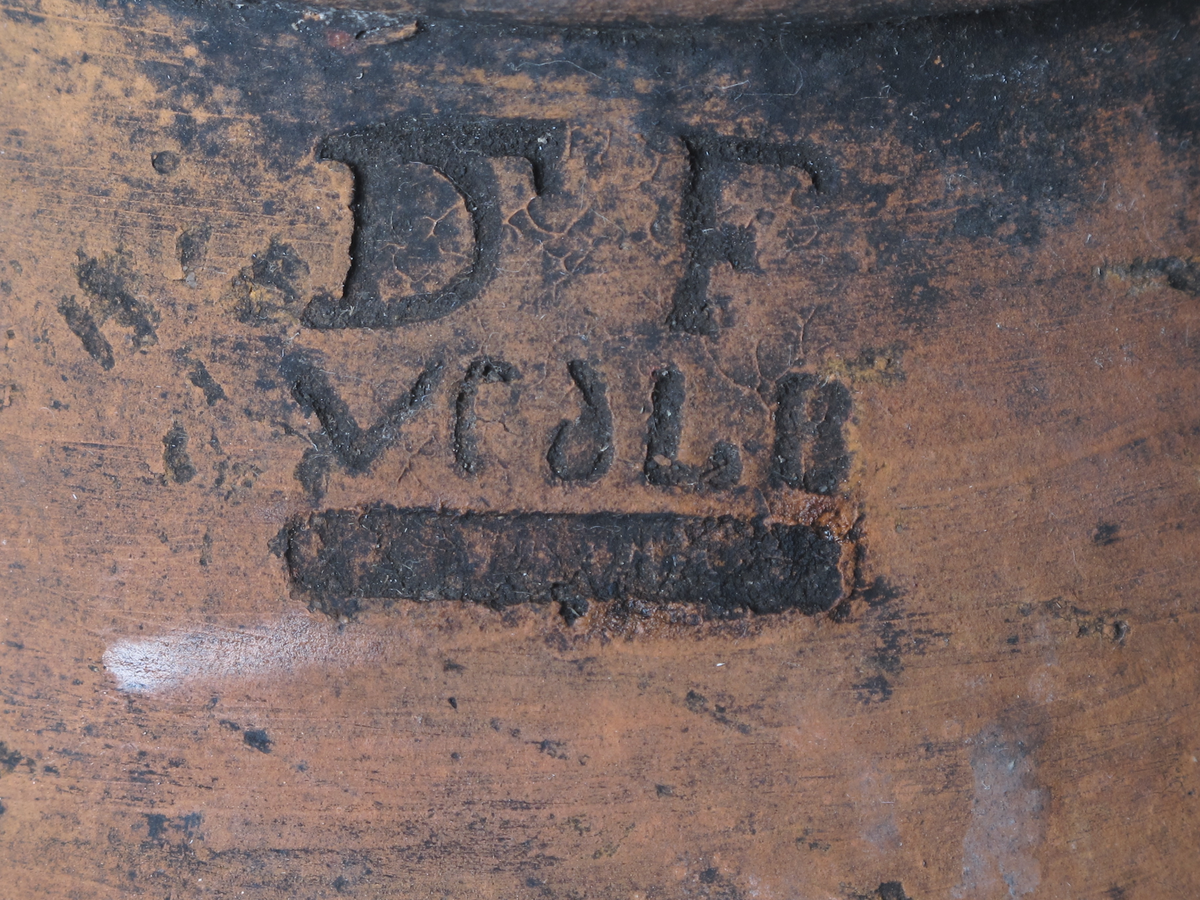 Krukke i keramikk. Krukken har en rett hals og en kropp med buet form som smalner mot en vinklet base.