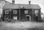 Den gamla trähuslängan utmed Trädgårdstorget i Linköping töms inför rivning 1926. Här gårdssidan mot det nordligast belägna huset invid korsningen Nygatan-Tanneforsgatan. Till vänster skymtar fastigheten Nygatan 25, som ännu består men mot torget med en förenklad fasad. På platsen för trähusen kom det så kallade Delfinpalatset att uppföras och i sammanhanget vidgades Trädgårdstorget till sin nuvarande rektangulära form.