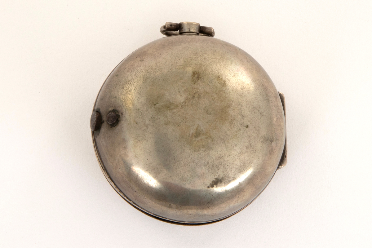 Spindelur med glatt ytterkasse og urkasse av sølv. Sølv tallskive med romerske og arabiske tall og minuttinndeling i relieff. I sentrum kartusj og merket: Town. Horncastle.