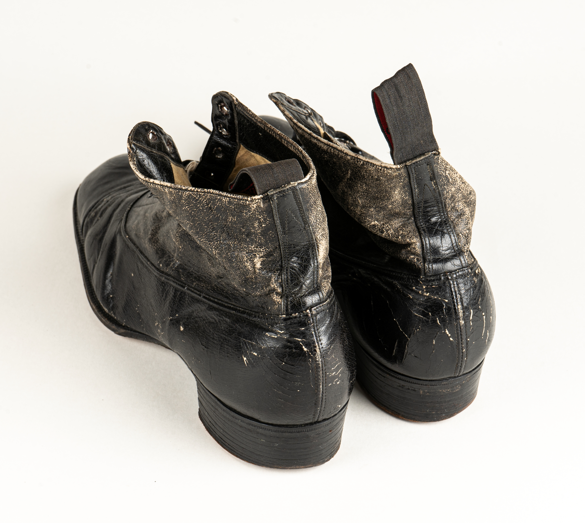 Ett par herrskor i läder som ägts av Karl Fredrik Jernberg, Alfta.  Tidigt 1900-tal. Skorna är svarta med halvhögt skaft. Snörning med både hål och hyskor.