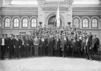 Stort antal män i studentmössor uppställda för foto framför Smålands Museum, ca. 1914.