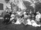 Släktfoto utomhus i trädgård framför bostadshus. Ca. 1895, okänd plats i Kronobergs län.