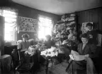 Hattaffär, 1909, troligen Växjö. Ett antal kvinnor sysslar med att tillverka/sy ett antal damhattar.