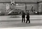 I11, den 30/1 1974.
Fem läkare med arméstabsläkare Olof Kylin i spetsen, anländer med helikopter från Stockholm för att hjälpa till med visitation/undersökning av 505 sjukanmälda.
Regementschefen överste Per Hugo Winberg avvaktar landningen.