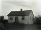 Huset har modernisertas med papptak, tjärad tegelskorsten och nya ytterdörrar med spröjsade fönster. Annars är det nog rätt ursprungligt från 1840-talet. Det ser ovanligt nog ut att ha en låg källare, se fönstren vid marken.