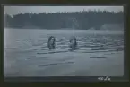 Två unga kvinnor badar i en sjö.

