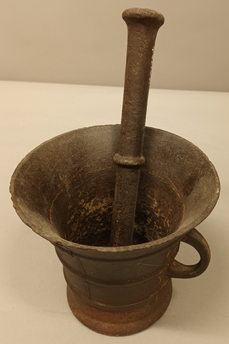 Morta er ein rund kopp som vidar seg ut oppe i ein slags trakt form. Liten rund hank på sida. Støytaren er ei stang som vidar seg ut i ein kluns i kvar ende. På midten er det ein ring som gjeng rundt sjølve støytaren.