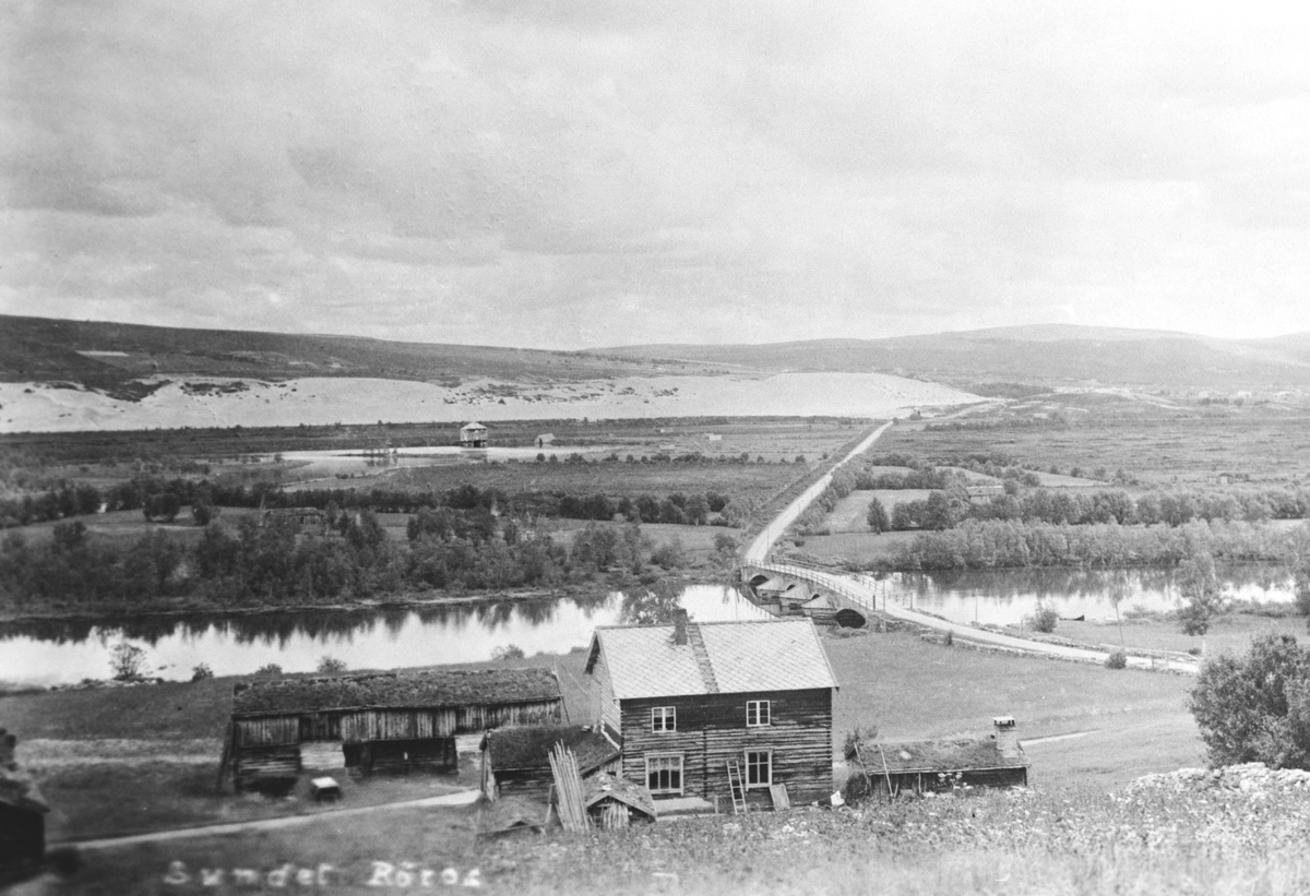 Søndre Sundet sett fra vest med gamle Sundbrua, Glåma, Håan og Kvitsanda i bakgrunnen. Ute ved Håan sees kobberverkets torvhus og båtnaust