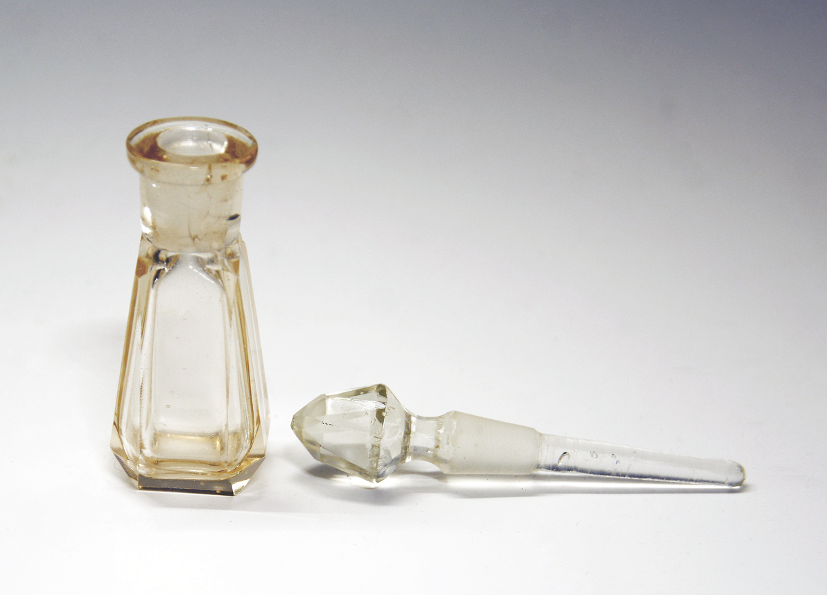 Parfymeflakong med kork. Glass, avflatete kanter, korktopp fasettslipt, som ender i en stift til påføring av parfymen.