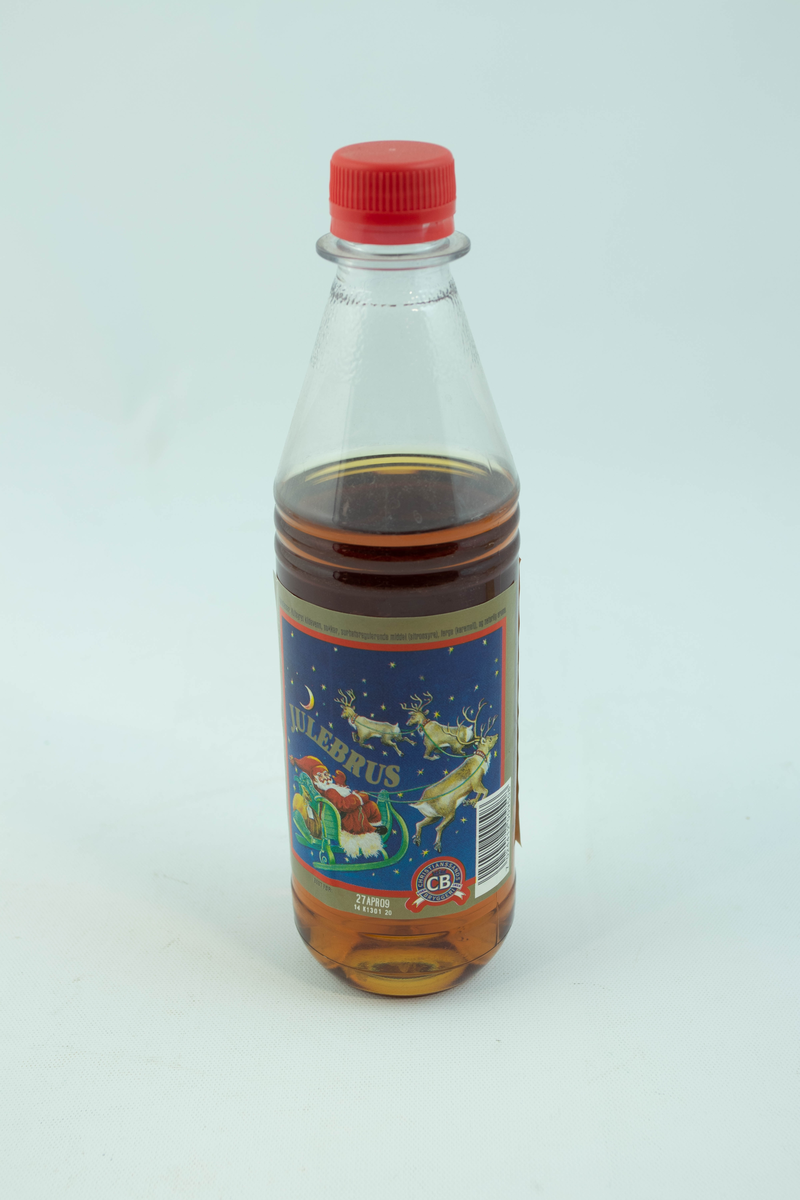 Klar plastflaske som har flerfarget etikett med julemotiv