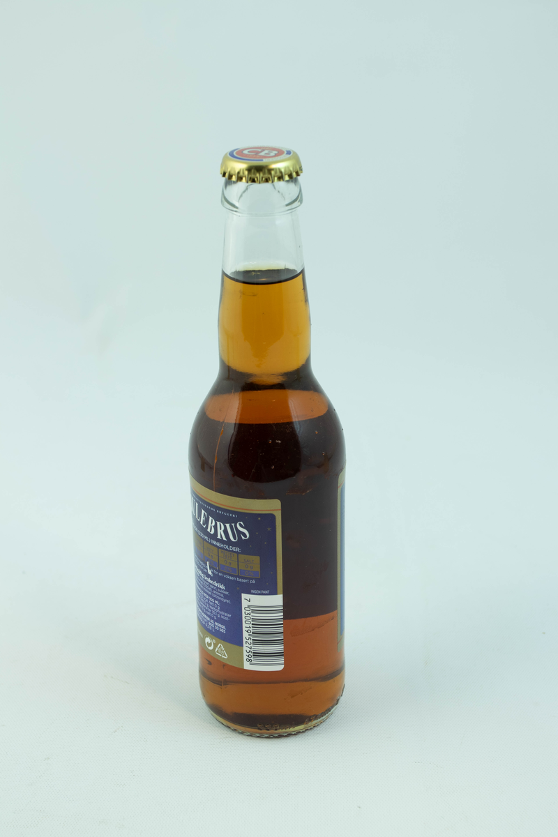 Klar glassflaske som har flerfarget etikett med julemotiv