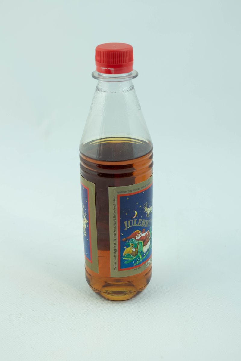 Klar plastflaske som har flerfarget etikett med julemotiv