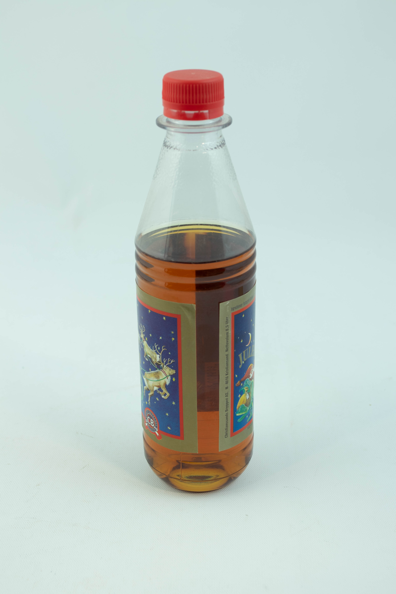 Klar plastflaske som har flerfarget etikett med julemotiv