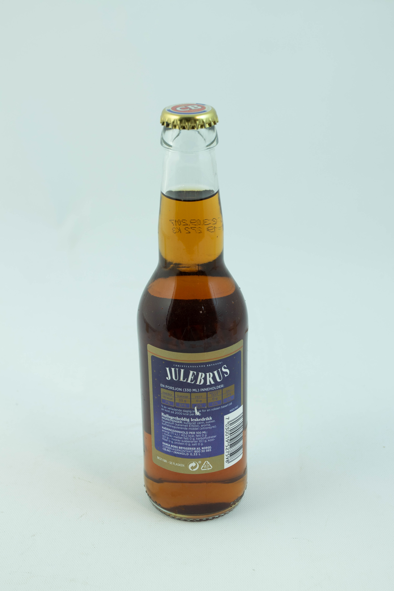 Klar glassflaske som har flerfarget etikett med julemotiv