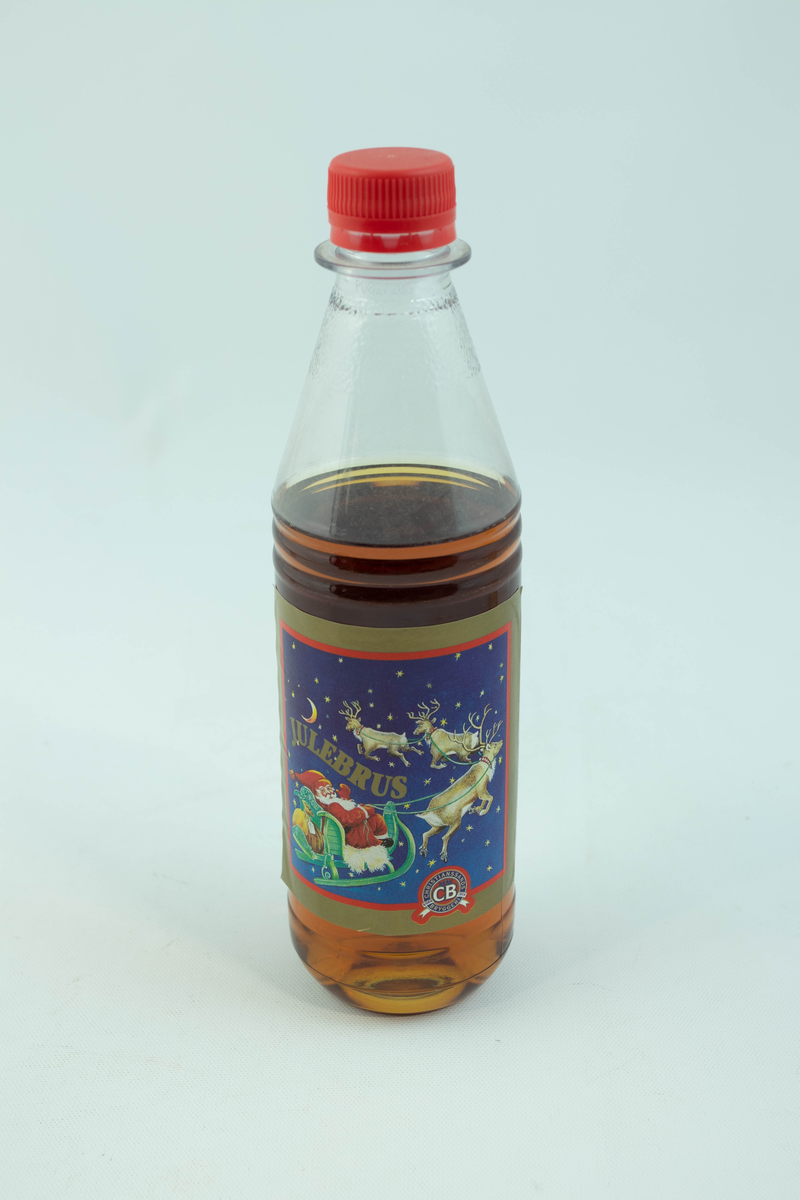 Klar plastflaske som har flerfarget etikett med julemotiv