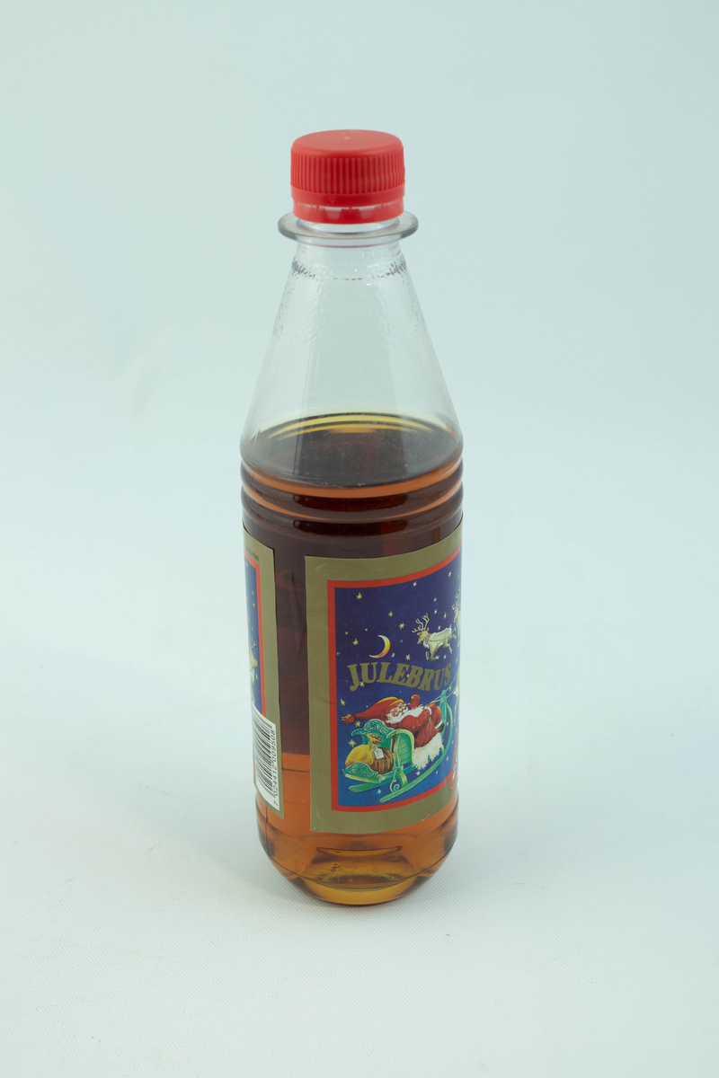 Klar plastflaske som har flerfarget etikett med julemotiv