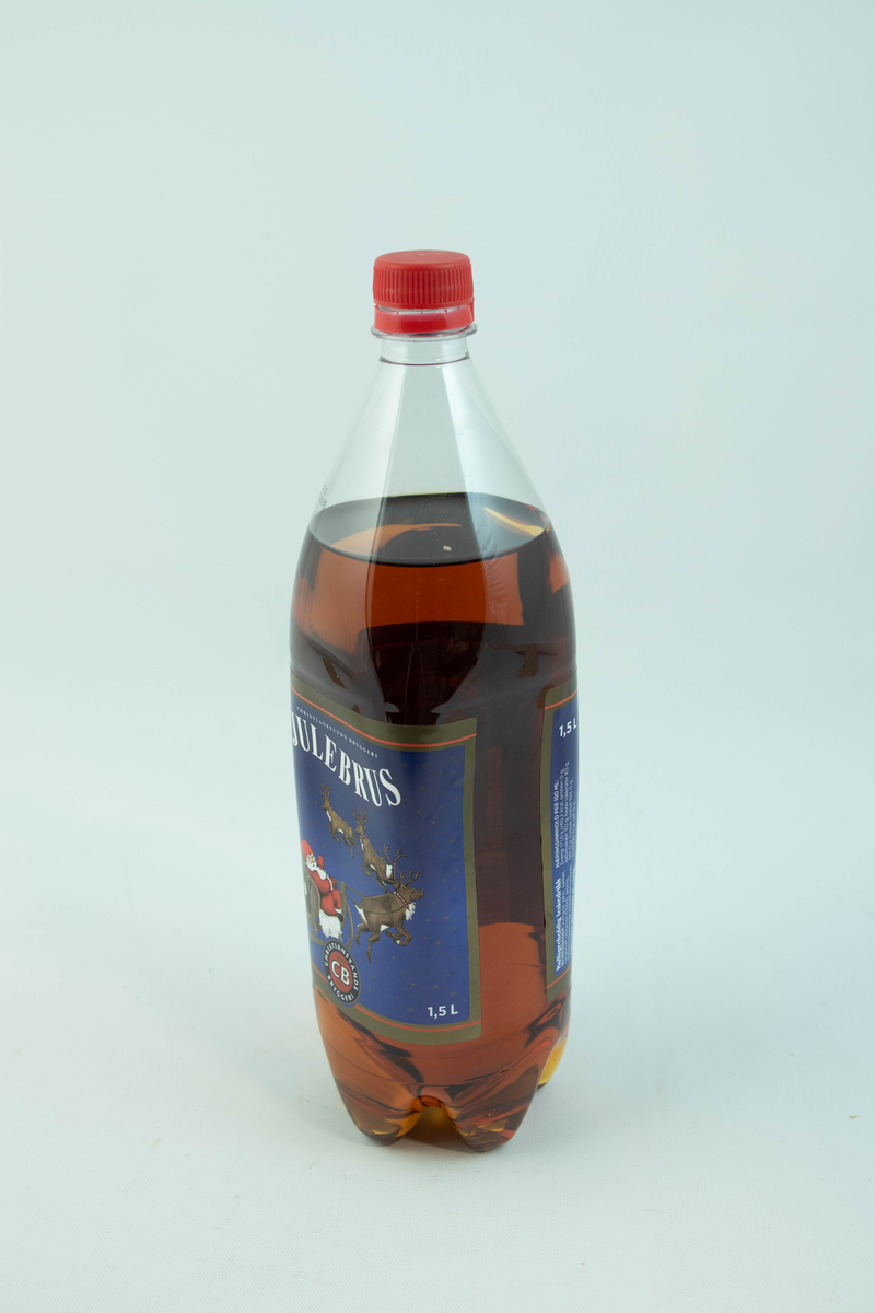 Stor klar glassflaske som har flerfarget etikett med julemotiv