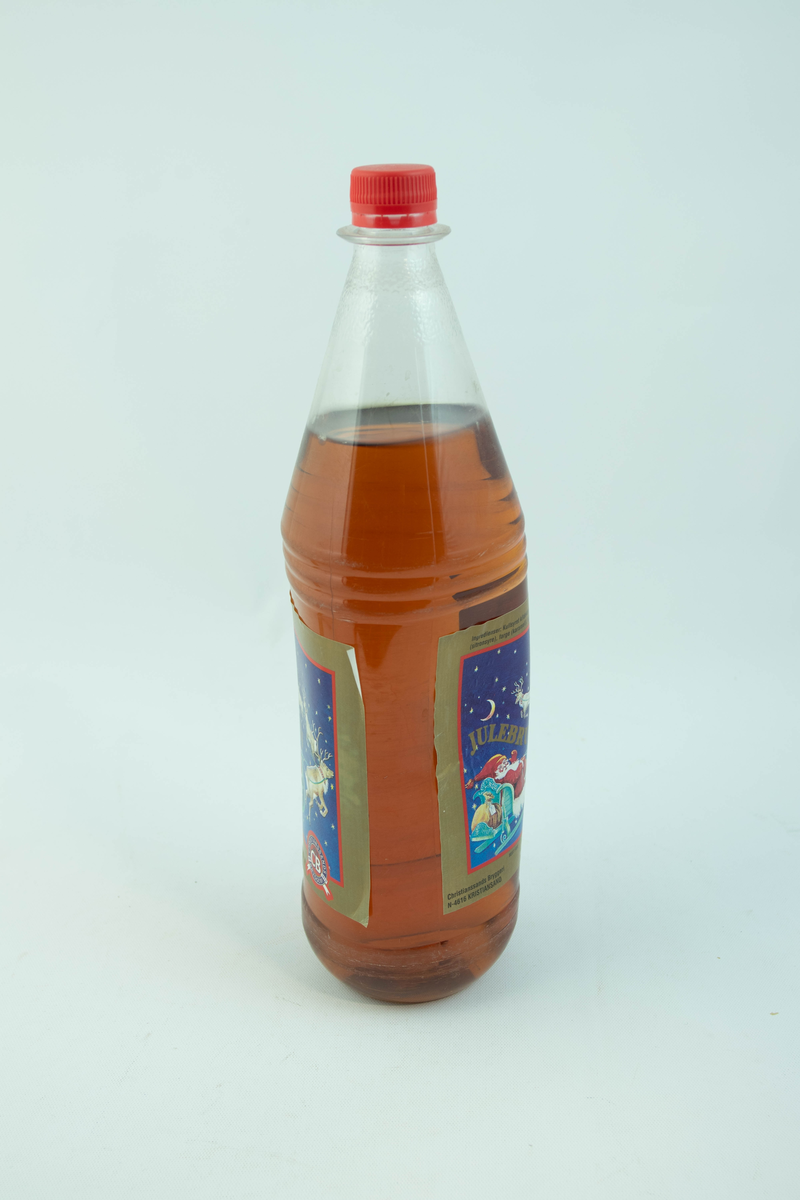 Stor klar plastflaske som har flerfarget etikett med julemotiv