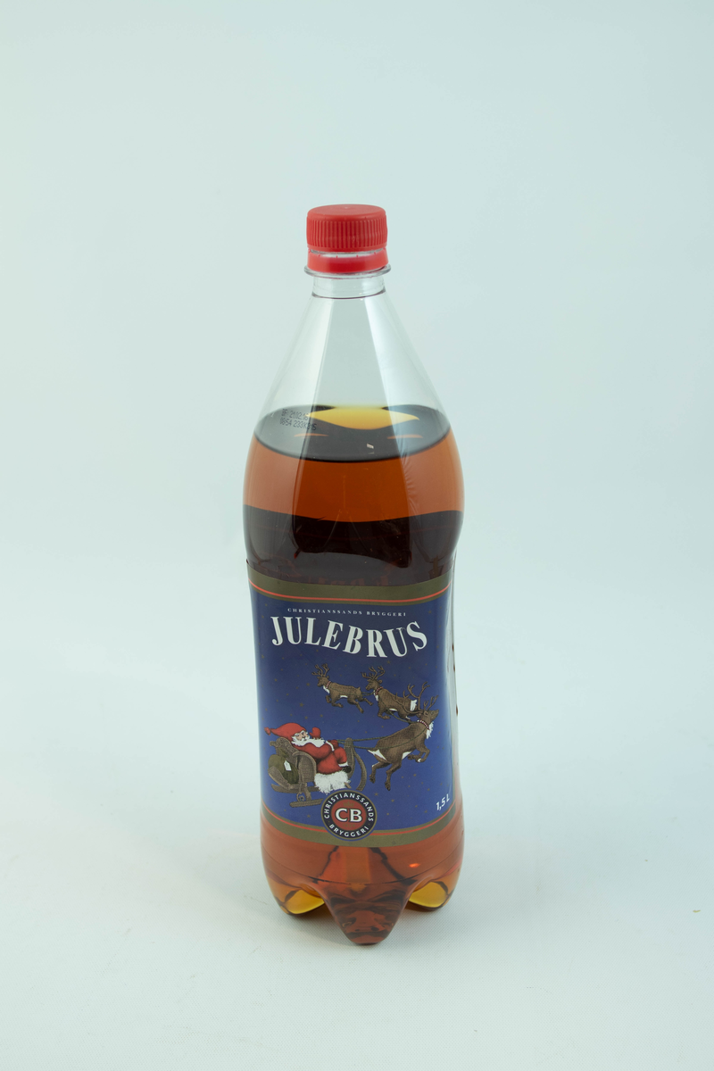 Stor klar glassflaske som har flerfarget etikett med julemotiv
