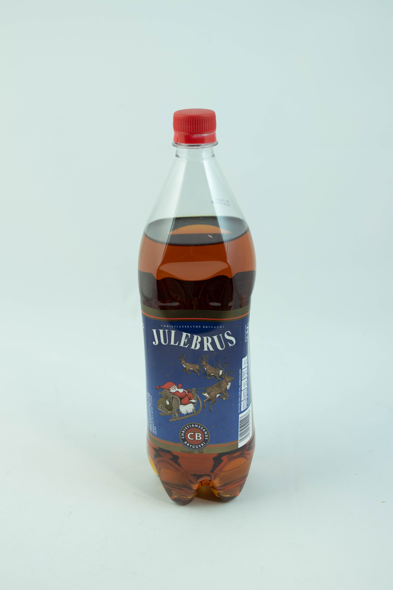 Stor klar glassflaske som har flerfarget etikett med julemotiv