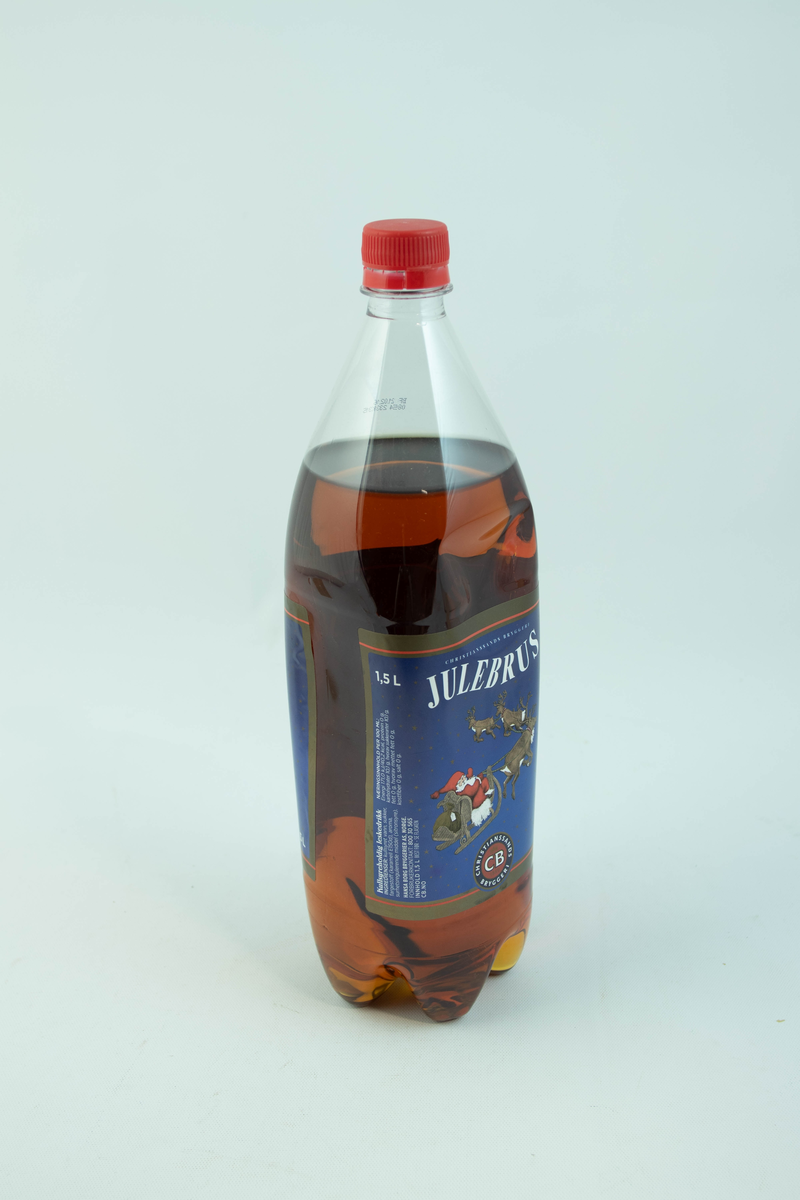 Stor klar glassflaske som har flerfarget etikett med julemotiv