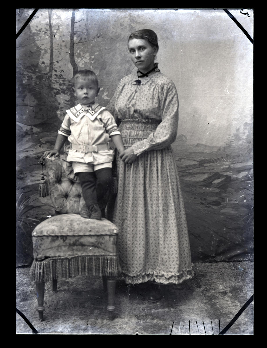 Atelierfoto. Helfigur. En ung kvinne og en liten gutt.