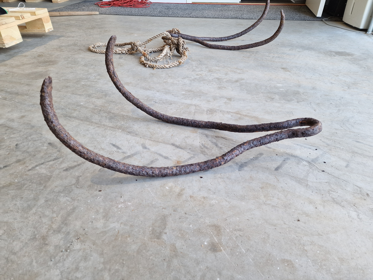 Metallstang, bøyd på midten og formet som to kroker som henger sammen med et "øye" (ikke helt rundt) til å feste tau i.