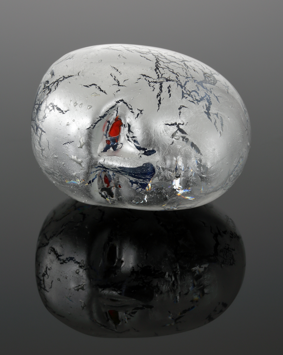 Prydnadsföremål i form av ett ansikte.
Silverfolierat med röda ögon.