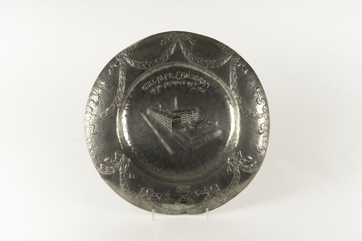 Ett dekorerat tennfat som överlämnades som födelsedagsgåva till Alfred Ehnström (?) år 1926 i samband med hans 70-årsfirande. Centralmotivet på fatet avbildar Pixfabriken. På brämet finns formgivarens namnstämpel: Astri Ekengren.