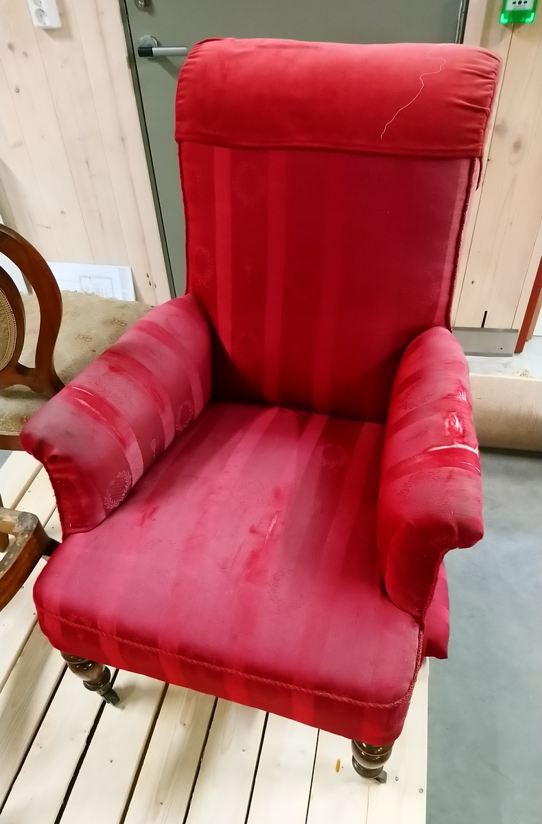 Lenestol med rødt trekk.