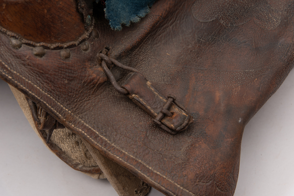 Håndlaget sal fra 1787. Bygd opp utifra en treform med lerret (strie). Pånaglet lær på sidene av stolen og på baksiden og yttersidene av selve stolen. Læret på den ene yttersiden av stolen er preget med inskripsjonen "1787 M.E.D.B." Stolen er innvendig fylt med stopp og trukket med grønt ullstoff som er påbrodert kruseduller. Læret er preget med en forenklet akantusranke. Salputen under er sydd i lerret (strie) og fylt med stopp, og festet kun på den ene siden. Alle remmene er i lær, nagler og spenner av jern.