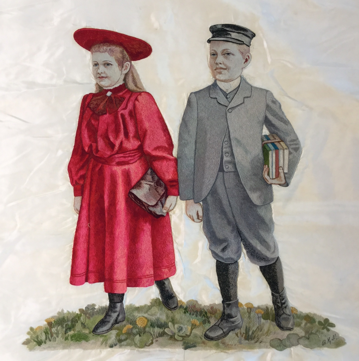 En gutt som holder skolebøker og ei jente med skoleveske er brodert midt på faneduken. Over er det brodert "Kongsvinger folkeskole" i store bokstaver. Under er det brodert "Fremad til lys og liv!" i store bokstaver.