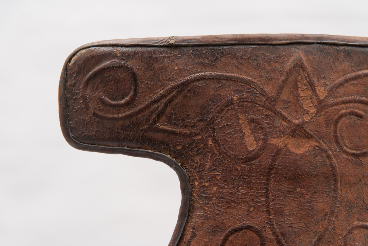Håndlaget sal fra 1787. Bygd opp utifra en treform med lerret (strie). Pånaglet lær på sidene av stolen og på baksiden og yttersidene av selve stolen. Læret på den ene yttersiden av stolen er preget med inskripsjonen "1787 M.E.D.B." Stolen er innvendig fylt med stopp og trukket med grønt ullstoff som er påbrodert kruseduller. Læret er preget med en forenklet akantusranke. Salputen under er sydd i lerret (strie) og fylt med stopp, og festet kun på den ene siden. Alle remmene er i lær, nagler og spenner av jern.