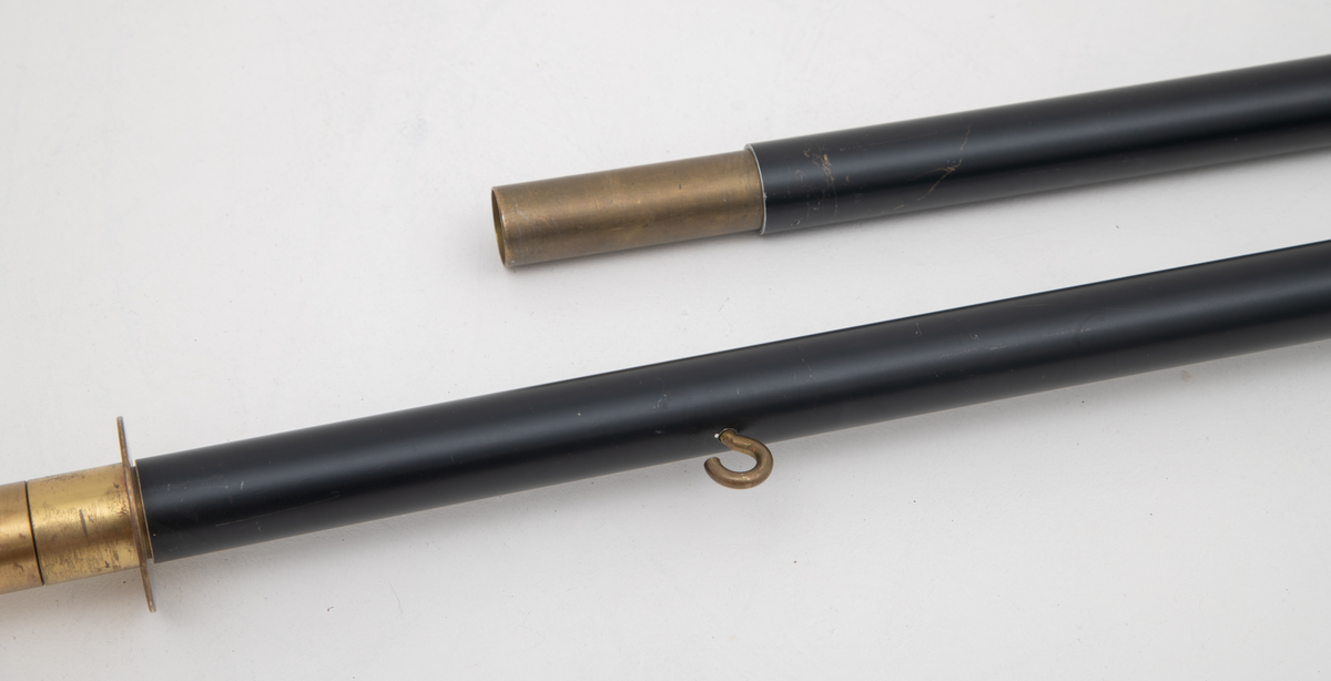 Svart fanestang i metall med toppstykke, platespyd. 

(Rektangulær faneduk i blått med gule påsydde snorer på hver side og frynser langs nederste kant. Bardun- og styresnorer og possement i gult.)